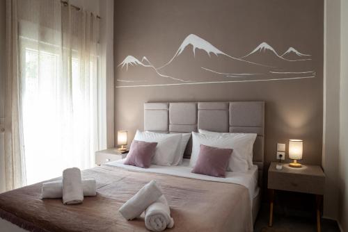 a bedroom with a large bed with mountains painted on the wall at Kalliope's house in Knossos in Knosos
