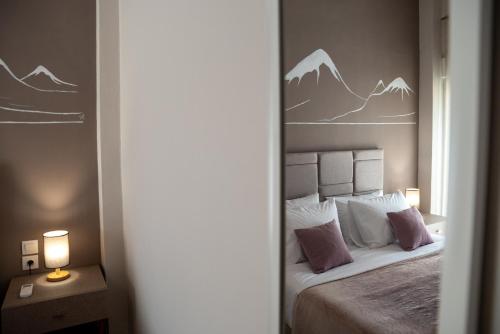 a bedroom with a bed with mountains painted on the wall at Kalliope's house in Knossos in Knosos