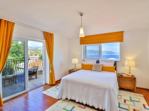 a bedroom with a large bed and a balcony at VILLA SCARLETT in Kaş