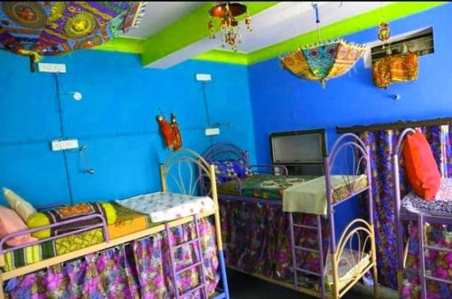 Cette chambre dispose de 2 lits superposés et de murs bleus. dans l'établissement House Of Touristers Hotel & Cafe, à Jaipur
