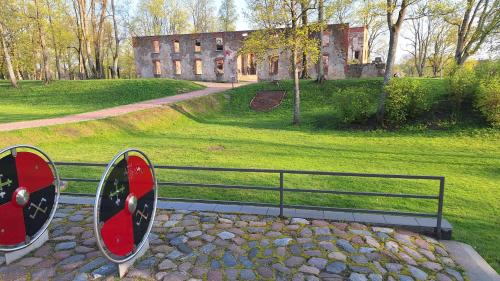 a park bench in front of an old building at Crow's nest in Grobiņa