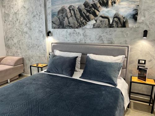 een slaapkamer met een bed met een schilderij aan de muur bij Hotel Ergi in Durrës