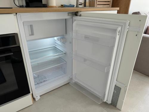 een lege koelkast met de deur open in een keuken bij Tiny Home in Aalsmeer