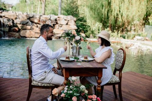 un uomo e una donna seduti a un tavolo con bicchieri da vino di Penzion U Zběhlíka a Svitavy