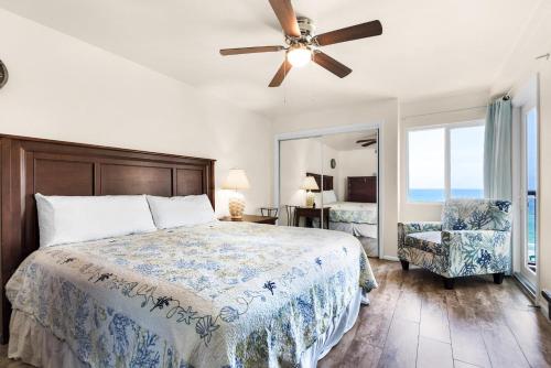 a bedroom with a bed and a fan and a chair at Holiday Surf and Racquet Club 707 in Destin