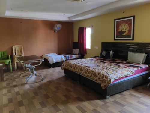 Sri Krishna Residency في فيساخاباتنام: غرفة نوم بسريرين وطاولة وسرير