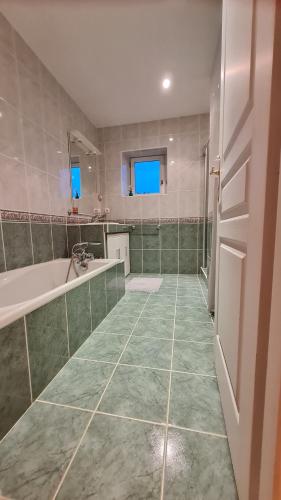 une salle de bain avec une baignoire et un lavabo dans l'établissement Impérial, à Puy-lʼÉvêque