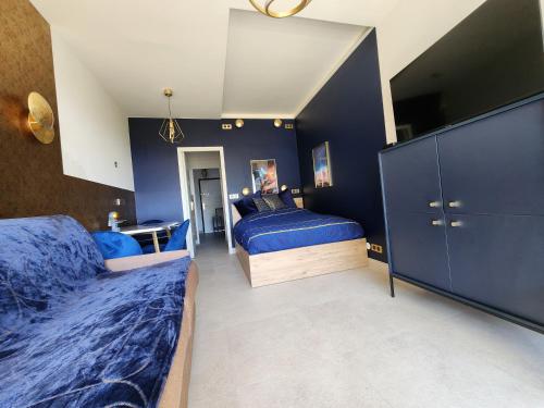 une chambre avec deux lits et un mur bleu dans l'établissement Studio Balcony Sea View - 6th floor - FAME MARINA BAIE DES ANGES, à Villeneuve-Loubet