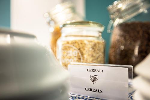 a table with jars of cereals and a sign at La Rosa Hotel - Selinunte in Marinella di Selinunte