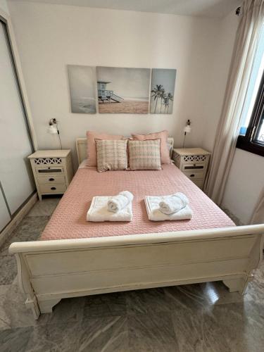 a bedroom with a large bed with two towels on it at Apartamento Universal in La Línea de la Concepción