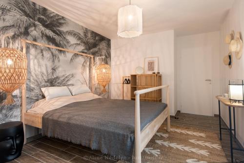 une chambre avec un lit avec un papier peint tropical dans l'établissement VILLA à 200m DE LA PLAGE - Saint-Palais-sur-mer, à Saint-Palais-sur-Mer