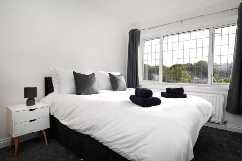 a bedroom with a large white bed with two towels on it at Beautiful Home in West Midlands 