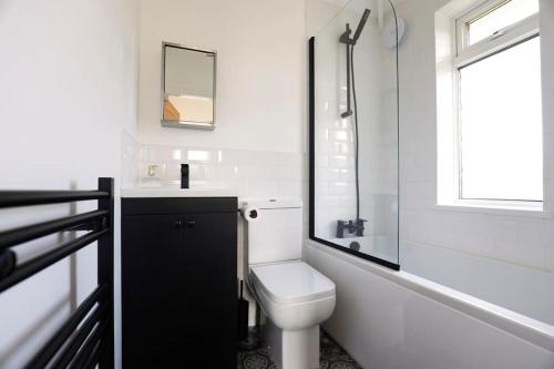 a bathroom with a toilet and a sink and a window at Beautiful Home in West Midlands 