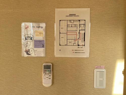 a wall with a remote control and a floor plan at Bonfire Hostel Osaka in Osaka