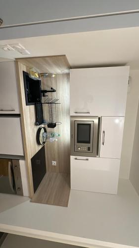 Il comprend une petite cuisine équipée d'un four micro-ondes et d'un comptoir. dans l'établissement Appartement neuf courbevoie Defense love A11, à Courbevoie
