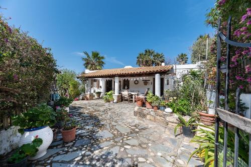 ein Haus mit einem Garten mit Topfpflanzen in der Unterkunft Paradiso Vintage Villa: Traditional 1944 Gem in Amanioú