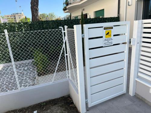een witte poort voor een hek bij The Twins 1 Luxury Home - Lungomare Viale Milano 20 in Riccione