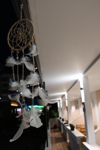 a group of white feathers hanging from a wall at Troy ApartHotel Durres in Durrës