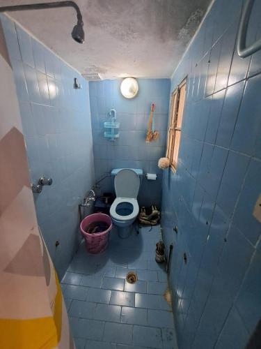 een blauw betegelde badkamer met een toilet en een raam bij Tanger med 3 in Tanger