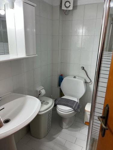 a white bathroom with a sink and a toilet at Cottage Oasis in Hanioti