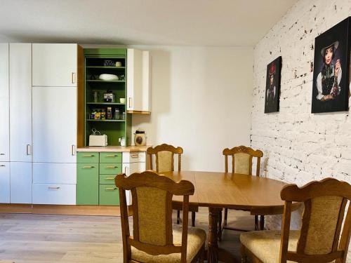 une cuisine avec une table en bois et des armoires vertes dans l'établissement Gemütliche Unterkunft in Baden-Baden direkt am Schwarzwald, à Baden-Baden