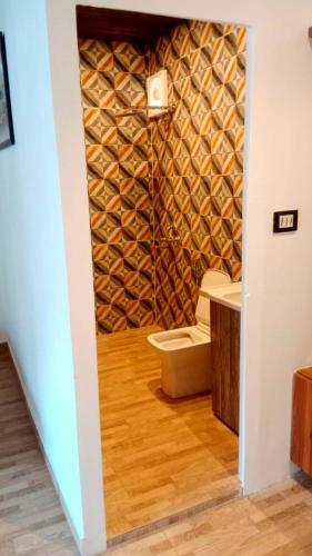 a bathroom with a toilet and a wall of wine bottles at AVTARA RESORT RISHIKESH in Rishīkesh