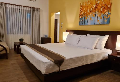 een slaapkamer met een groot bed in een hotelkamer bij City Oasis 66 in Negombo