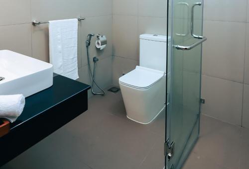 een badkamer met een toilet en een glazen douche bij City Oasis 66 in Negombo