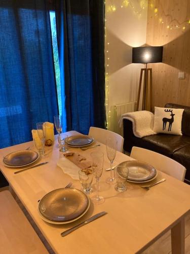 une table avec des assiettes et des verres à vin dessus dans l'établissement La marmotte: Vue Mont Blanc, terrasse, parking, à Combloux