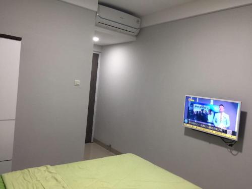 um quarto com uma televisão de ecrã plano na parede em Surya Maju Landmark Residence em Bandung