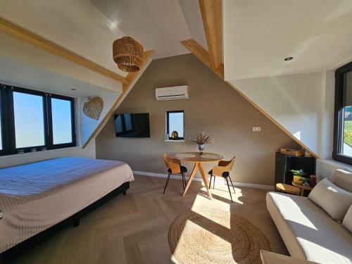 sypialnia z łóżkiem, stołem i kanapą w obiekcie Ybizee w mieście Yerseke