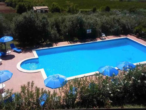a swimming pool with blue umbrellas and a swimming poolvisor at Il Podere degli Asinelli in Citta' Sant'Angelo