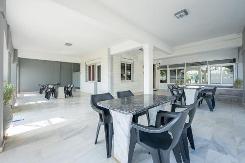 comedor con mesa de mármol y sillas en Dionisos Apartments, en Paralia Dionisiou