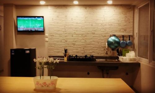 uma cozinha com uma mesa e uma televisão na parede em Surya Maju Landmark Residence em Bandung