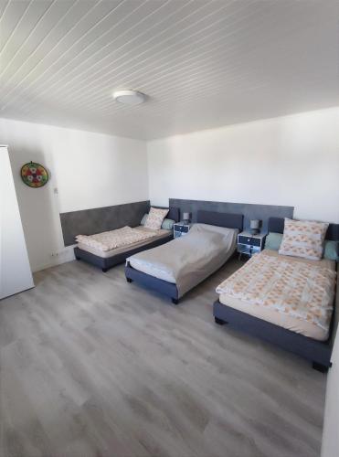 une chambre avec deux lits dans une pièce dans l'établissement Agréable Maison, toute équipée, proche du lac d'Arjuzanx, à Morcenx