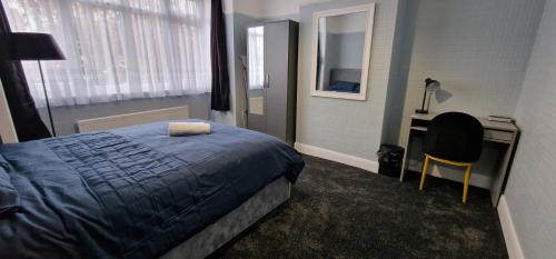 a bedroom with a bed and a desk and a chair at Rowan Crescent's Luxury Stay-In in Streatham Vale