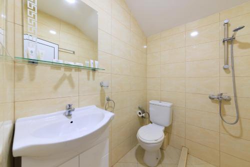 uma casa de banho com um lavatório, um WC e um chuveiro em Hotel Angy em Golden Sands