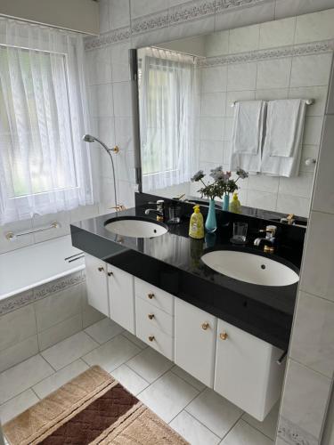 łazienka z 2 umywalkami i dużym lustrem w obiekcie Chlösterli w Lucernie