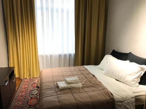 a bedroom with a bed with two towels on it at Уютный уголок рядом с ЦУМом и ГУМом in Bishkek