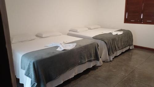 two beds sitting next to each other in a room at Pousada Girassol in Maceió