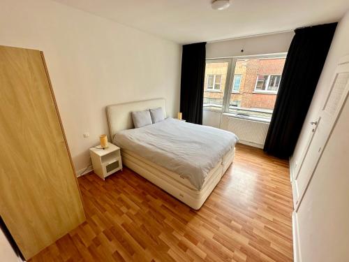 a small bedroom with a bed and a window at Appartement rénové in Brussels