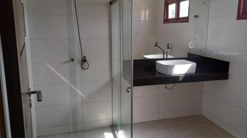 a bathroom with a sink and a glass shower at Pousada Girassol in Maceió