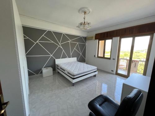 - une chambre avec un lit et une chaise dans l'établissement Casa vacanza La casa delle Onde, à Torrenova