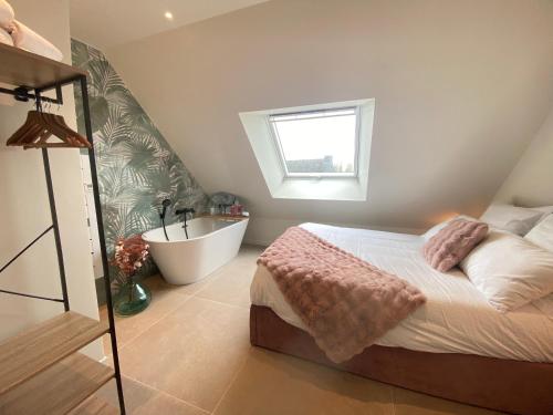 - une chambre avec un lit, une baignoire et une fenêtre dans l'établissement La Pause de Gabin - Terrasse - Parking, à Vannes