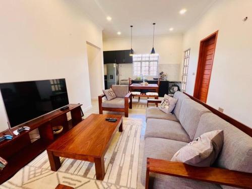 ein Wohnzimmer mit einem Sofa und einem Tisch in der Unterkunft Serenity Homes Arusha in Arusha
