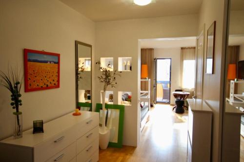 a living room with a white dresser and mirrors at Cozy flat with side Baltic Sea view in Pärnu