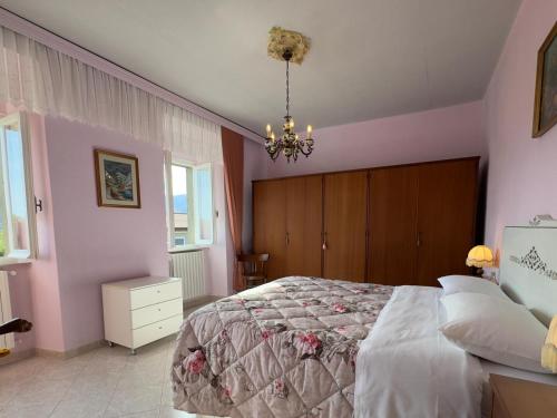a bedroom with a large bed and a chandelier at Casa Vacanza Nonna Lida in Villafranca in Lunigiana
