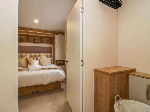 una camera da letto con letto, lenzuola e cuscini bianchi di Lakeland Dream a Warton