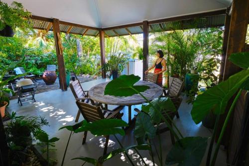 a woman walking on a patio with a table and chairs at Serenity in Picnic Bay
