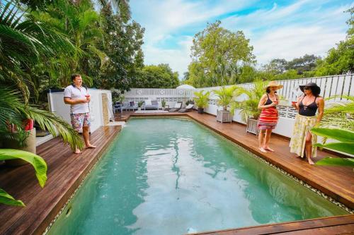 a group of people standing next to a swimming pool at Serenity in Picnic Bay